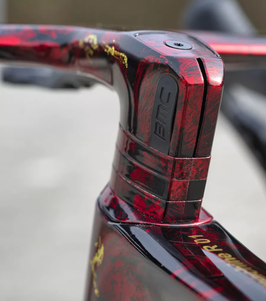 Gros plan sur la peinture personnalisée or et rouge d'un BMC Teammachine