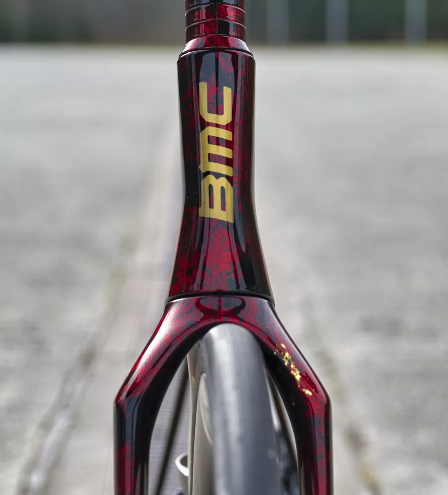 Détail de la fourche d'un BMC Teammachine avec finition rouge intense et reflets dorés